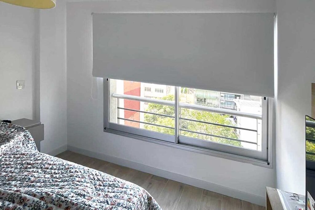 Habitación con cortinas roller black out blancas